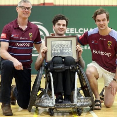 Wheelchair rugby player Conor Tweedy poses with his father and brother on court after a win